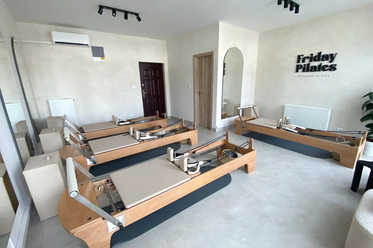 The interior of the Reformer Pilates studio features four modern reformer machines with a bright, minimalist design at Friday Pilates in Zugló, the 14th district of Budapest.